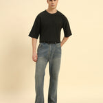 Model wearing the Dark Green Aeternum Jacquard T-Shirt styled with grey trousers - Men's sophisticated casual look