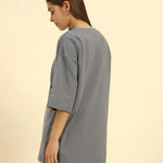Woman wearing an oversized French terry t-shirt for women in dark grey, showcasing its relaxed fit and comfort.