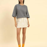 Oversized French terry t-shirt for women in dark grey, paired with a white skirt and yellow socks.