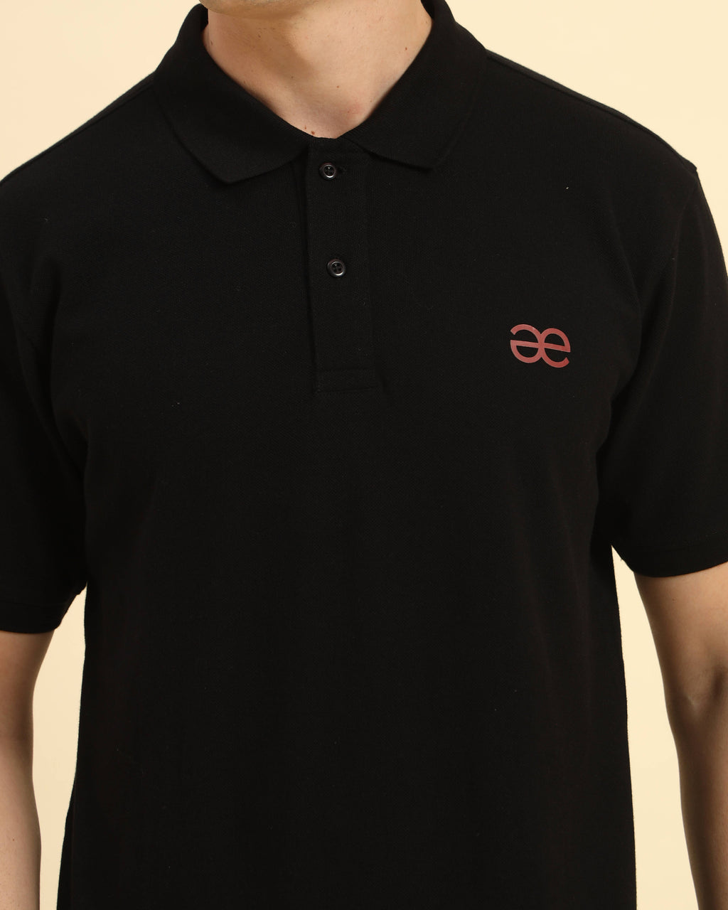 Close-up of the button placket and collar on the Aeternum Men's Black Polo, featuring high-quality piqué knit