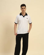 Full body view of the White Aeternum Cotton Polo styled with dark trousers for a classic aesthetic.
