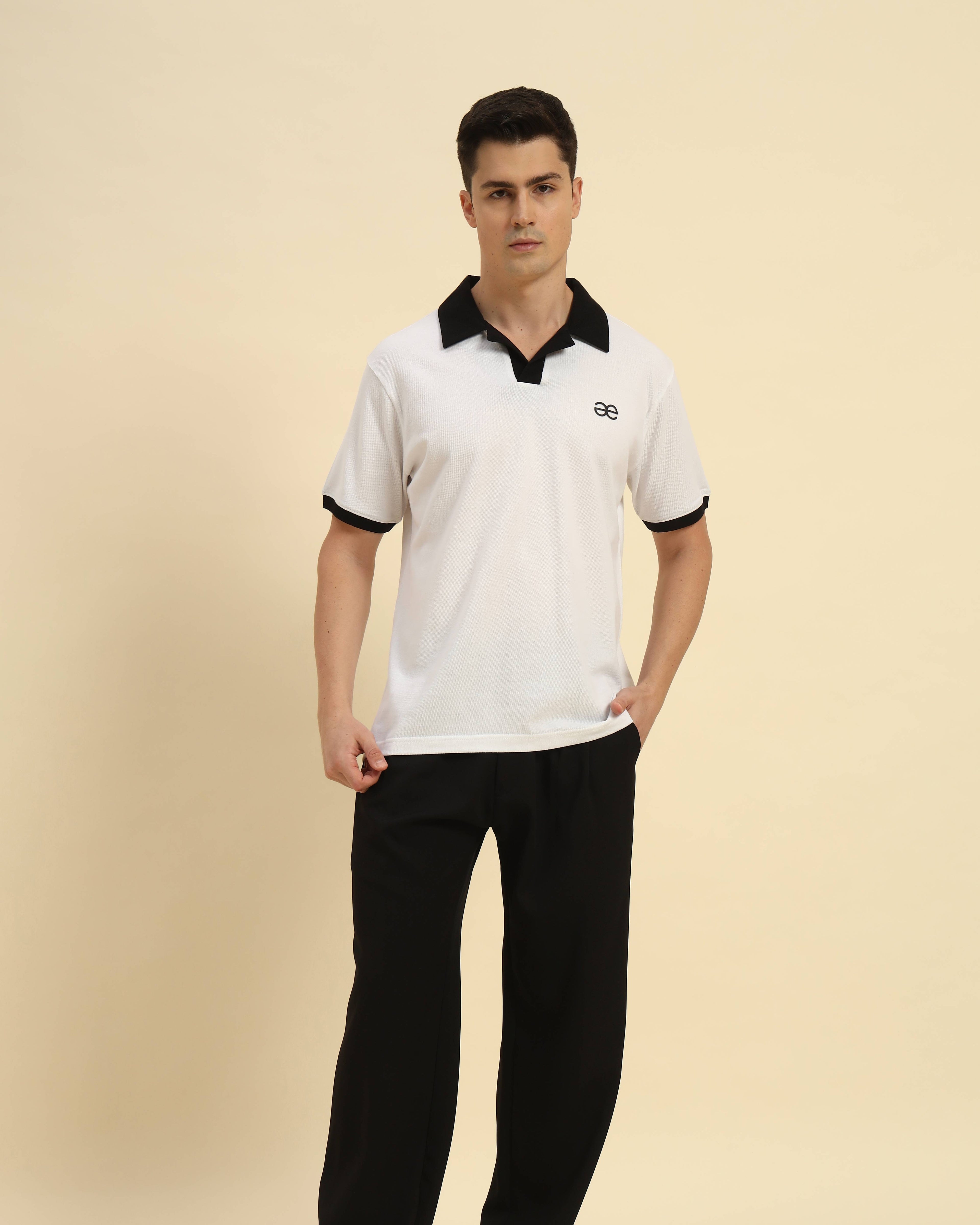 Full body view of the White Aeternum Cotton Polo styled with dark trousers for a classic aesthetic.