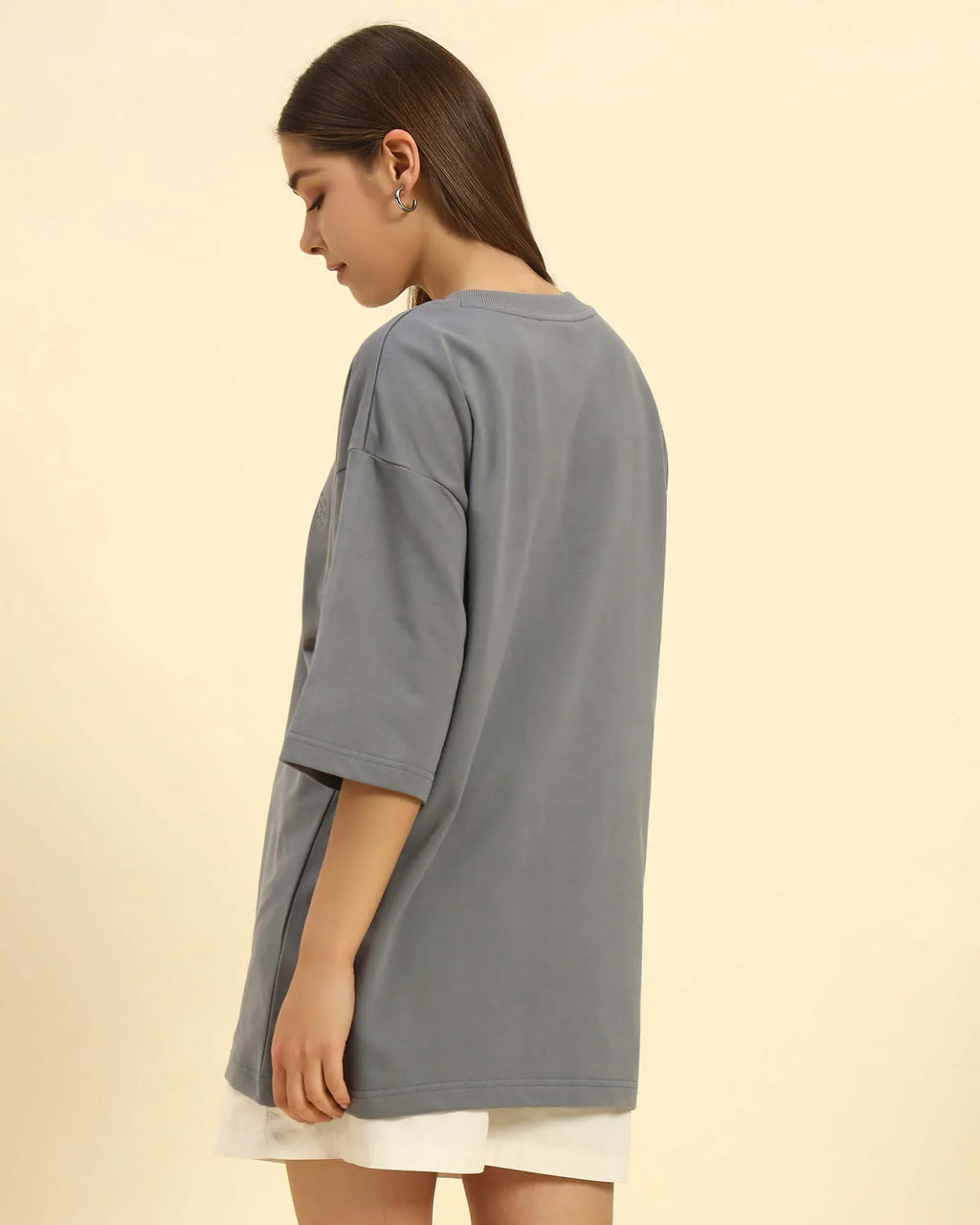 Woman wearing an oversized French terry t-shirt for women in dark grey, showcasing its relaxed fit and comfort.