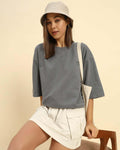woman wearing dark grey oversized French terry t-shirt for women with a bucket hat and beige skirt