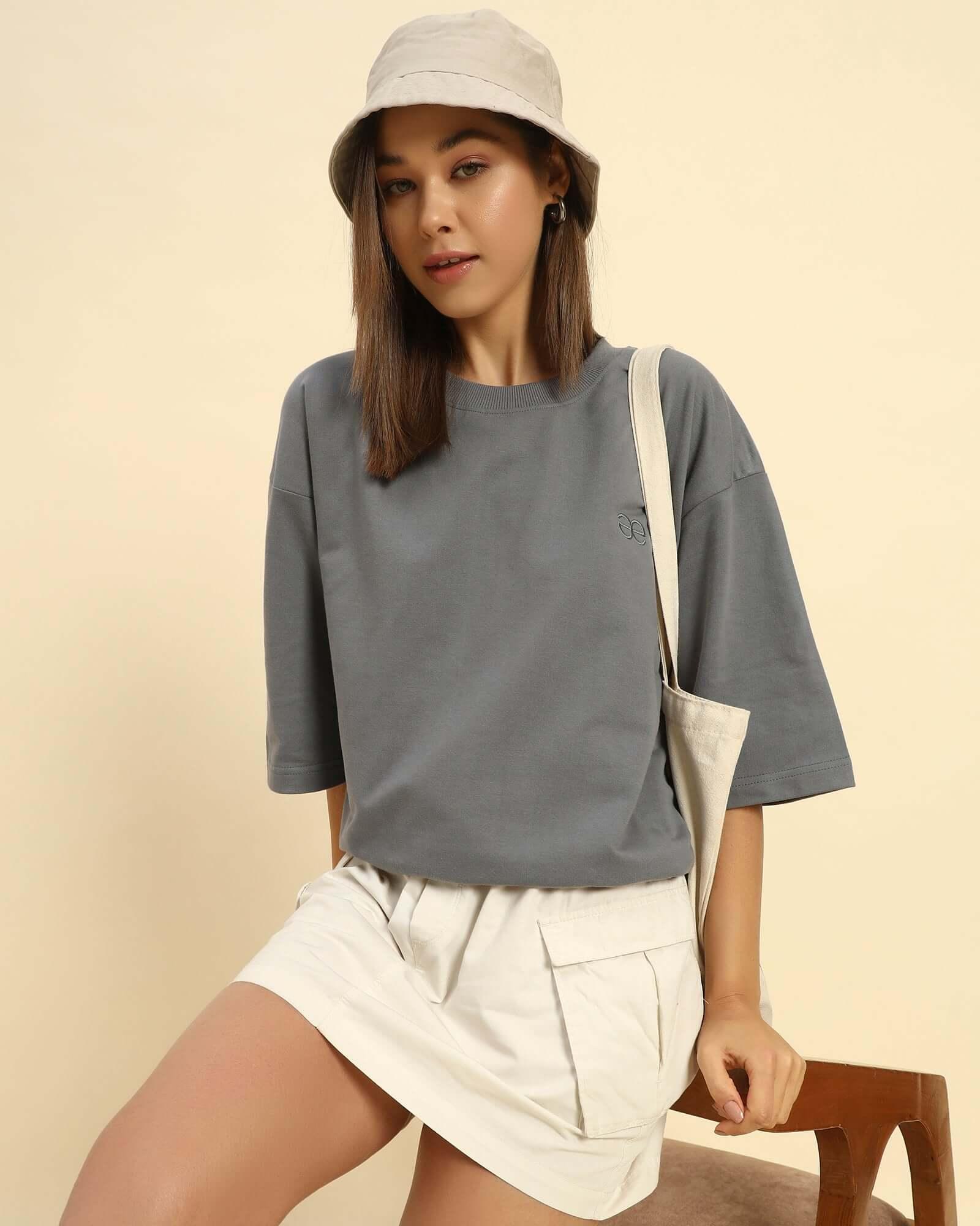 woman wearing dark grey oversized French terry t-shirt for women with a bucket hat and beige skirt