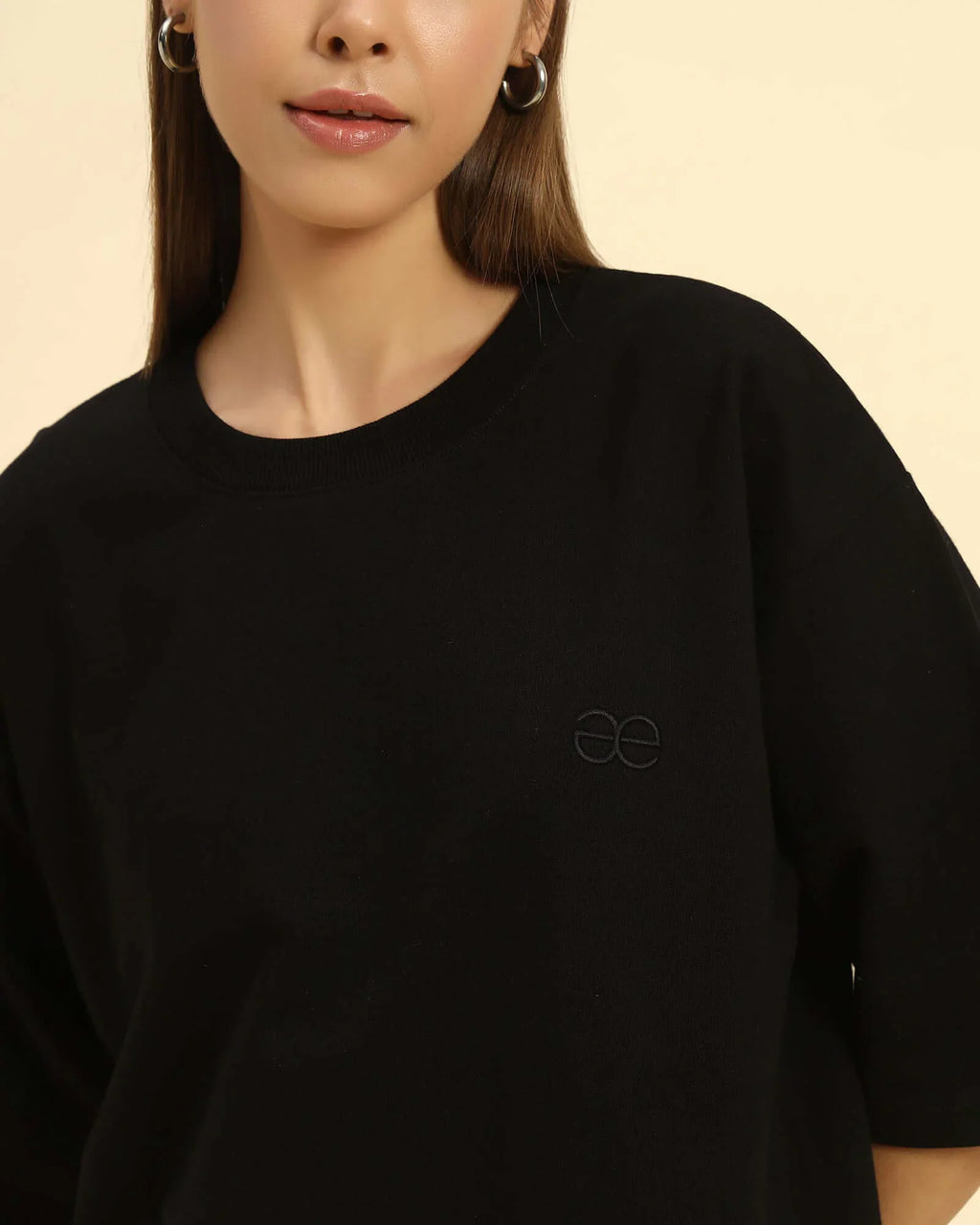 Aeternum Women's Oversized T-Shirt in black with embroidered logo worn by a woman.