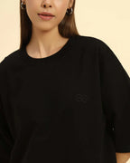 Aeternum Women's Oversized T-Shirt in black with embroidered logo worn by a woman.