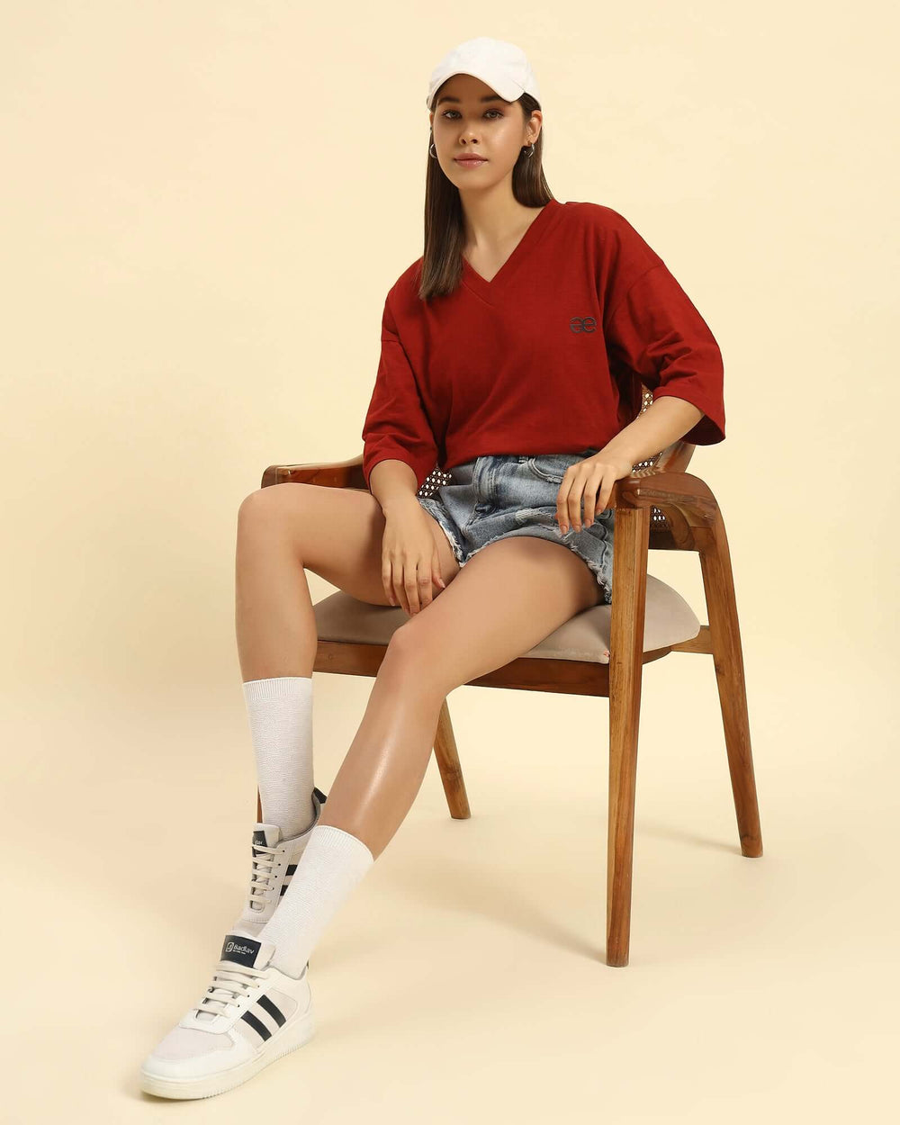 Model seated wearing the Aeternum Oversized V-Neck T-Shirt in Red, demonstrating the versatile loungewear style.