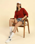 Model seated wearing the Aeternum Oversized V-Neck T-Shirt in Red, demonstrating the versatile loungewear style.