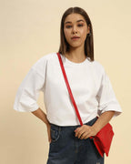AE Oversized French Terry Crew Neck T-Shirt | White | Woman being worn by a model with a red bag.