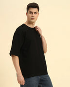 Side view of the Black Aeternum Men's Oversized T-Shirt showcasing the relaxed sleeve construction.