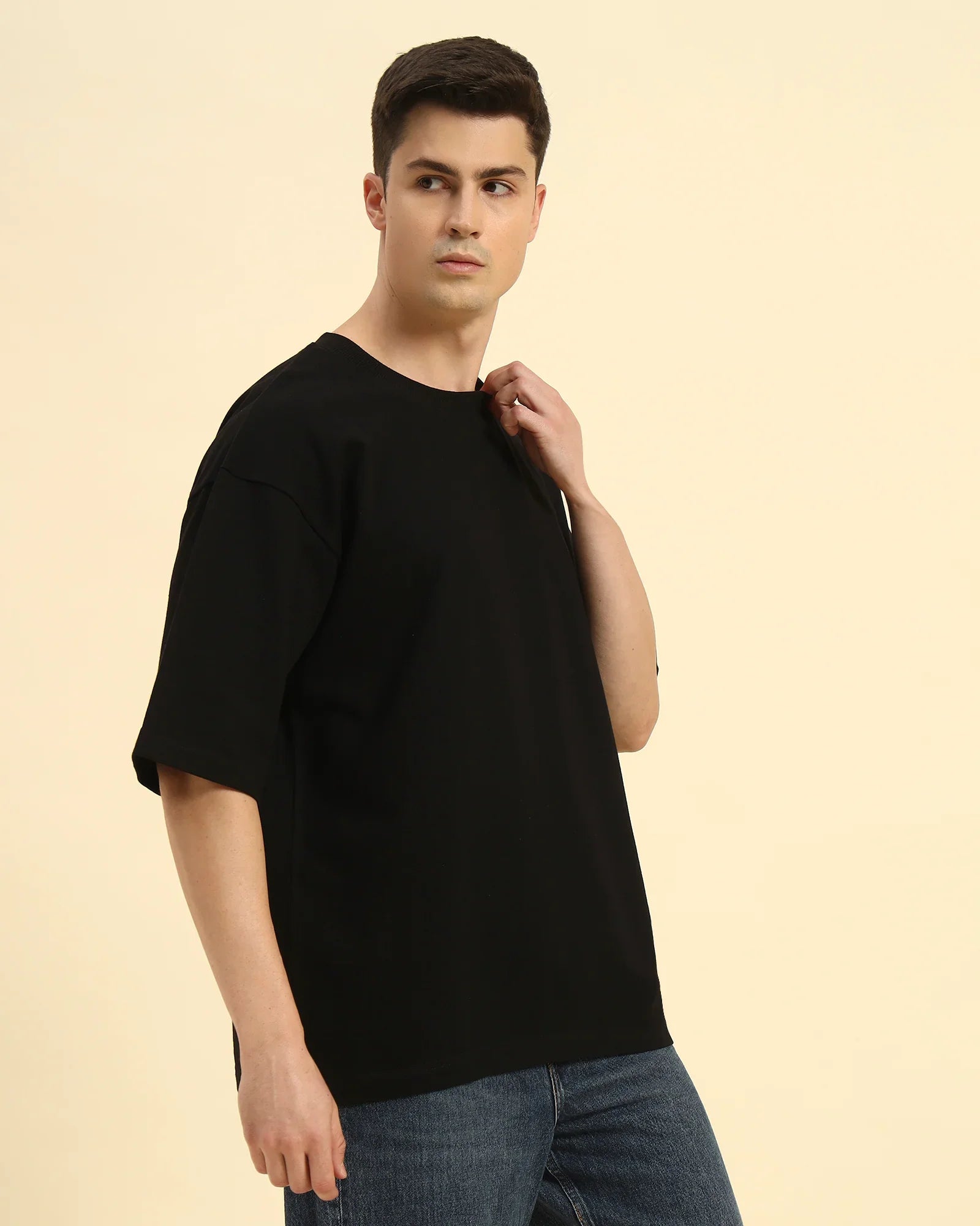 Side view of the Black Aeternum Men's Oversized T-Shirt showcasing the relaxed sleeve construction.