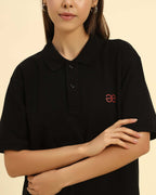 Close-up of the button placket and breathable cotton piqué texture on the Aeternum Women's Black Polo