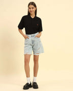 Model wearing the Black Premium Classic Fit Cotton Polo styled with light denim shorts - Women's casual sophisticated look