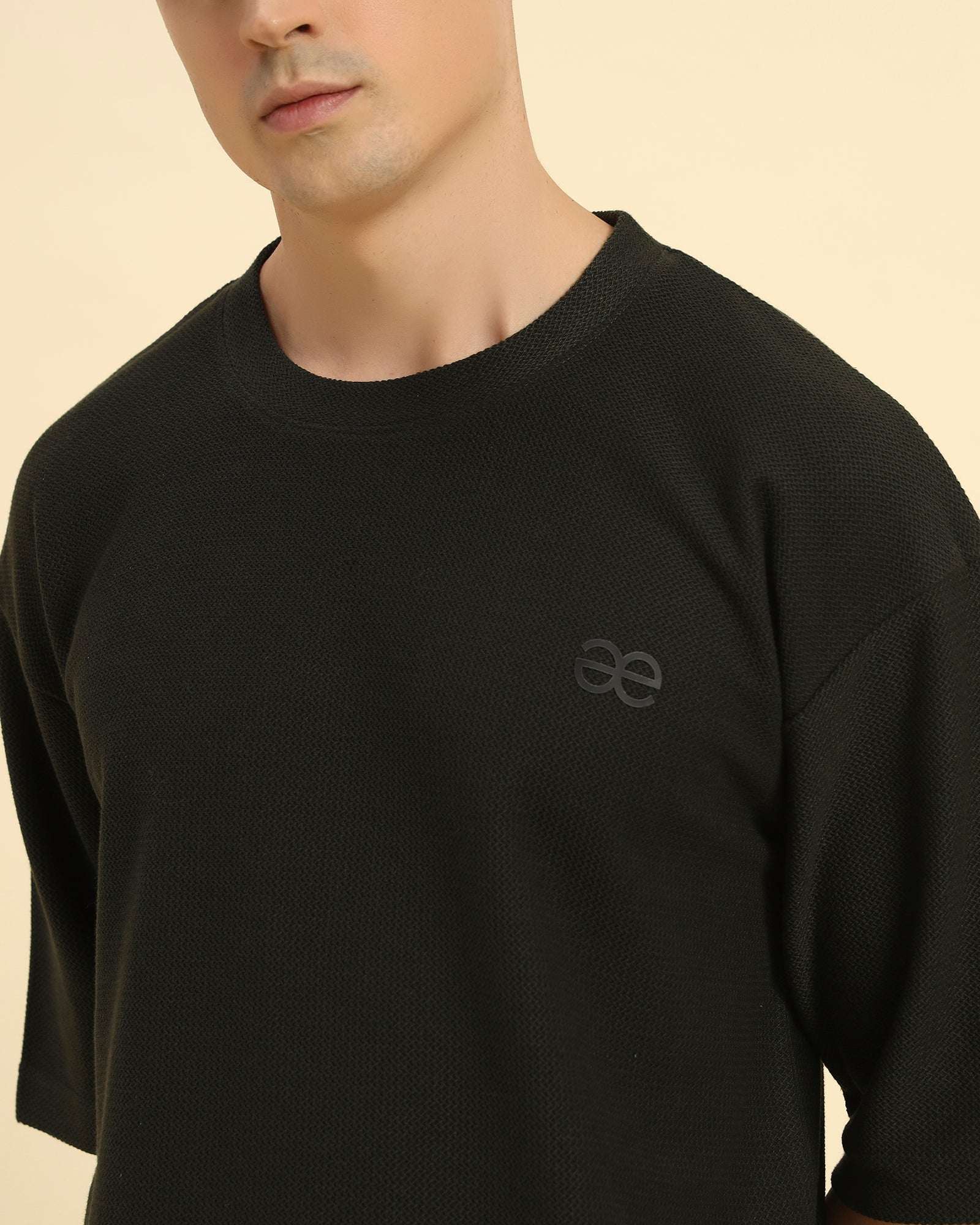 Close-up of the round neckline and intricate jacquard knit texture on the Aeternum Men's Dark Green T-Shirt.