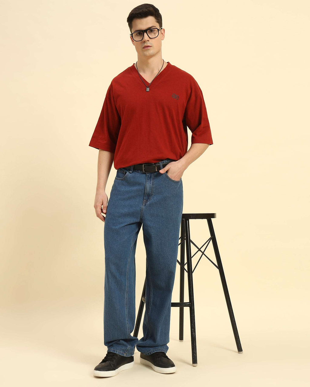 Lifestyle view of the Men's Aeternum Oversized Cotton Slub T-Shirt in Red showing casual styling while seated.