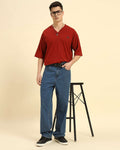 Lifestyle view of the Men's Aeternum Oversized Cotton Slub T-Shirt in Red showing casual styling while seated.
