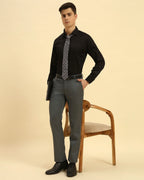 Model seated wearing the Aeternum Men's Classic Fit Giza Cotton Satin Shirt in Black, showcasing its elegant and versatile aesthetic.