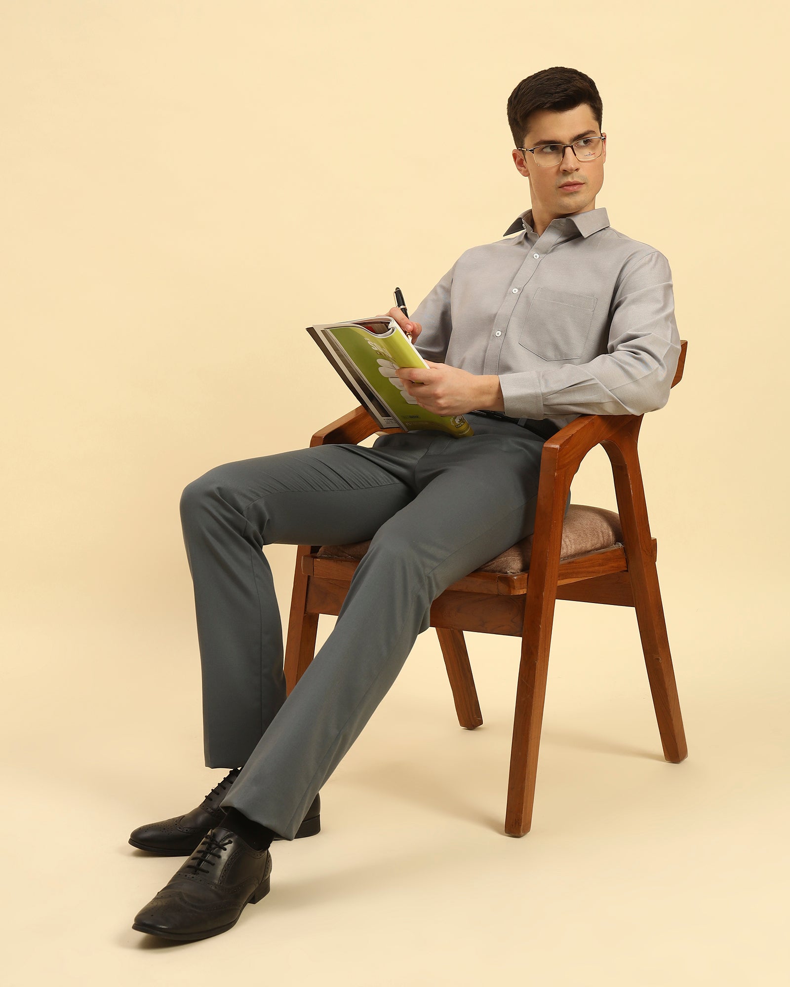 Model seated wearing the Aeternum Men's Classic Fit Textured Cotton-Blend Shirt, showcasing its breathable and stylish design.