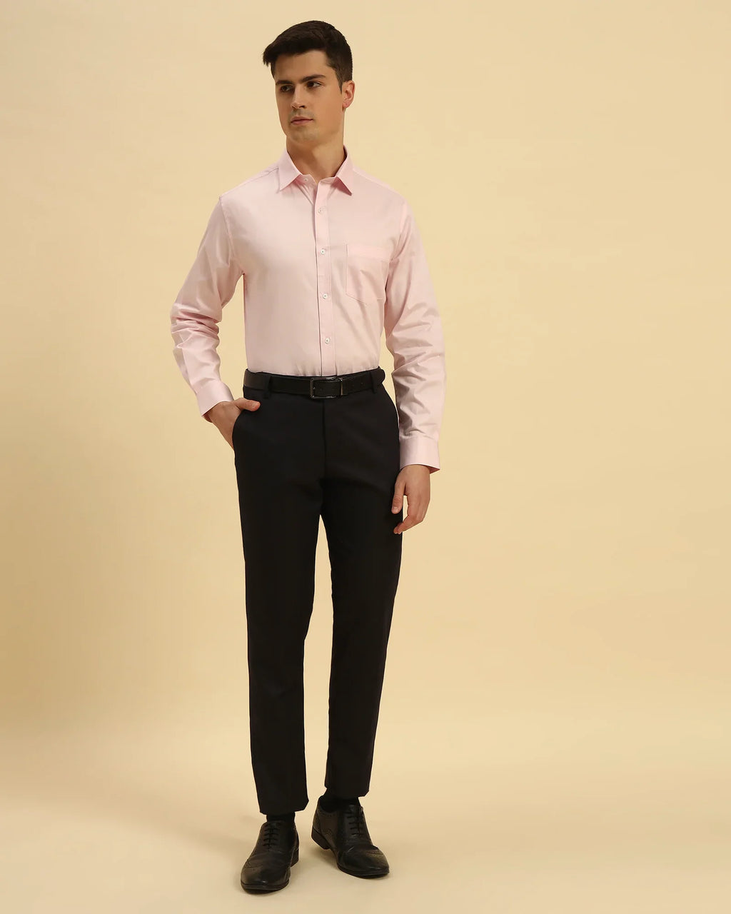 Full body view of the Aeternum Men's Light Pink Textured Shirt styled with dark trousers for a smart-casual aesthetic.