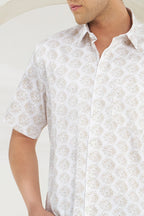 Man wearing a white short-sleeve shirt with a subtle pattern on a plain background